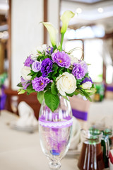 Bouquet in a vase. Purple and white flowers. The concept of a party and wedding decor.
