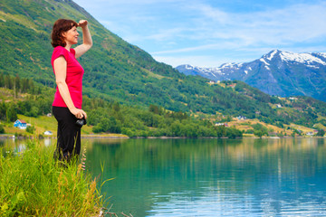 Naklejka na ściany i meble Tourist woman enjoying fjord view in Norway