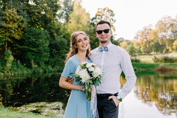 A nice, warm portrait of a stylish bridegroom and a charming bride in the nature