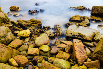 Fototapeta na wymiar Colourful rocks and water at Diamond Head coast, Australia