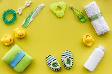 bath cosmetic set for kids, towel and toys yellow background top view space for text