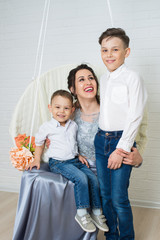 Fototapeta na wymiar Portrait of happy young mother and two sons on white studio background