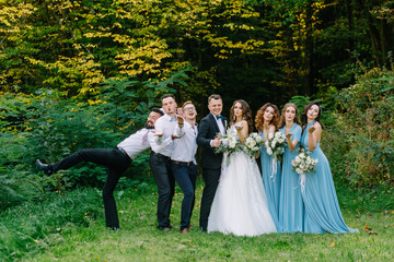 Guests at the wedding send an air kiss to the camera in nature in summer