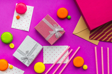Birthday greeting cards and wrapped gifts on fuchsia background top view