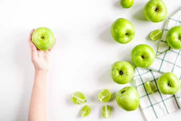natural food design with green apples in hands white desk background top view