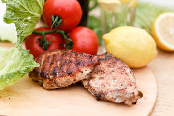 Сhicken breast grilled on a wooden Board. Chicken chili steak on the background with vegetables and black soda and lemonade, food photography