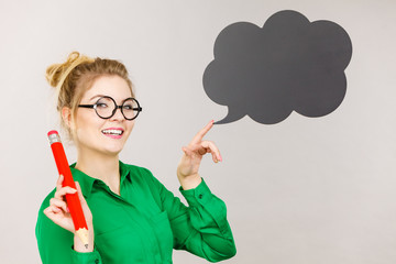 Woman holding big oversized pencil thinking