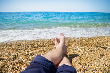 men's feet on the beach