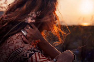 Obraz premium zamknąć się piękna młoda kobieta o zachodzie słońca