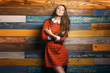 Woman student in red dress on colorful Wooden Wall Background