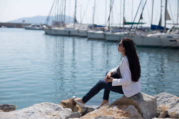 woman dressed in nautical style sitting by seaside