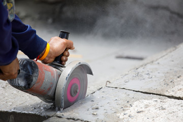 Worker using tool to cut concrete floor