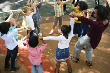 Group of diverse kindergarten kids arms raised