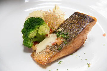  grilled salmon steak on mixedl vegetables with sauce