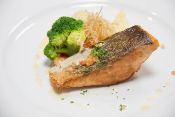  grilled salmon steak on mixedl vegetables with sauce