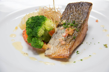  grilled salmon steak on mixedl vegetables with sauce