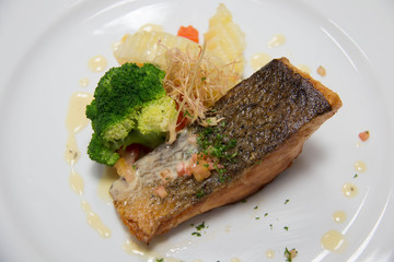 grilled salmon steak on mixedl vegetables with sauce