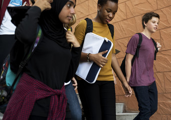 Fototapeta premium Group of school friends walking down staircase