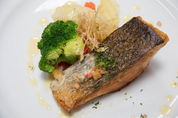  grilled salmon steak on mixedl vegetables with sauce