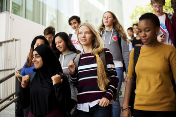 Group of school friends walking down staircase
