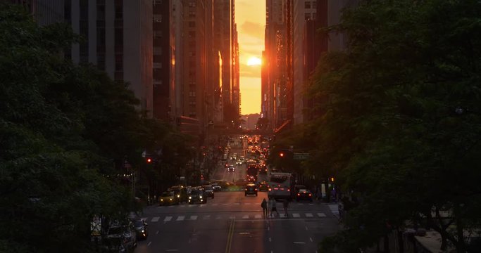 A dramatic wide evening long establishing shot over 42nd Street in New York City during the "Manhattanhenge" solar event.  	