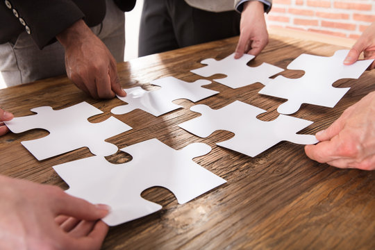 Businesspeople Arranging The Puzzle