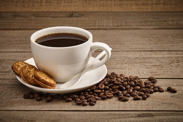 Cup of coffee and coffee beans with wooden table