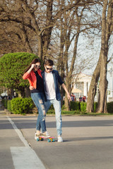 Fototapeta na wymiar Man learns girlfriend to skateboard