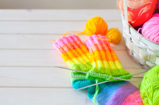 Closeup of basket with colorful yarn clews. Knitted Socks.