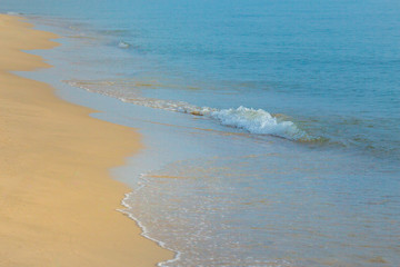 wave of blue ocean on sandy beach.