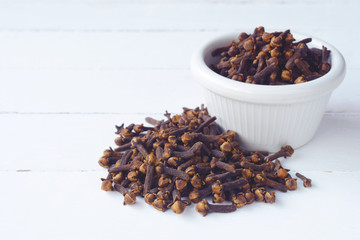 Cloves on white wooden table in the background.