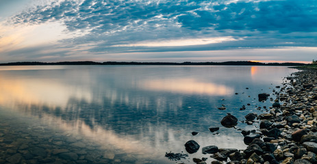 Seascape panorama with calm water and scenic clouds