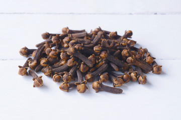 Cloves on white wooden table in the background.