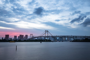 Fototapeta na wymiar modern suspension bridge over river at twilight
