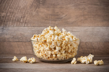 Popcorn in a bowl on the wooden table.
