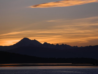 Sunrise over a mountain peak by still water