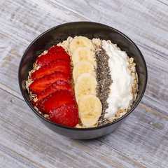 Muesli made from red strawberries, banana, chia seeds, oat flakes, honey and dressed with yogurt