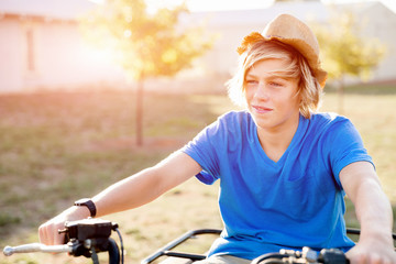 Boy riding farm truck in vineyard