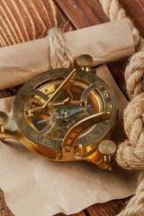 Compass and rope on wooden table. close up
