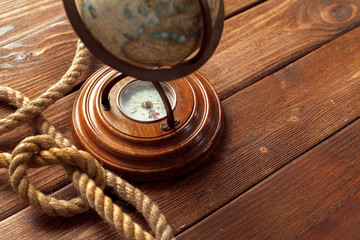 Compass and rope on wooden table. close up