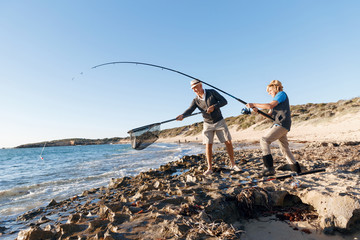 Senior man fishing with his grandson