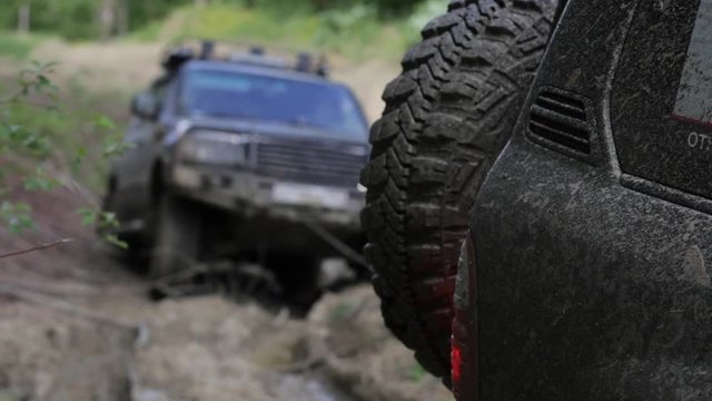 Expeditionary SUV got stuck in the mud in the forest and get out via another SUV