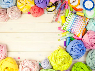 Accessories for sewing lie on a white background. Measuring tape, thread, fabric, needle bar and needles for sewing.