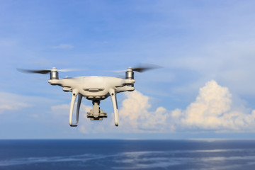 Naklejka na ściany i meble New drone flying over the sea on blue sky while taking landscape photos