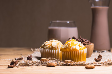 Sweet muffins with almond on  wooden table.