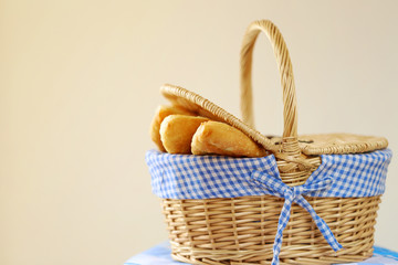 Fried pies in a wicker basket for a picnic   on a beige background. Traditional Homemade Baked Patties and Pies. 