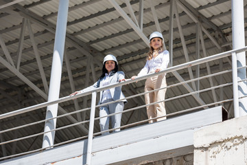 architects in formal wear looking at camera while standing at construction site