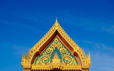 Gold color roof of buddhist temple with blue sky background.