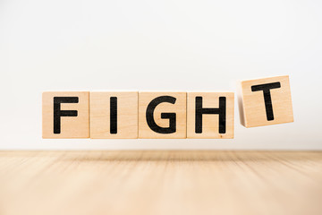 Surreal abstract geometric floating wooden cube with word "FIGHT" concept float on wood floor white background
