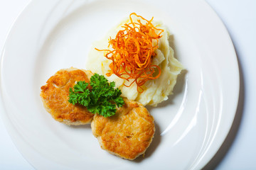 Homemade fried meatballs with mashed potatoes on white plate close up
